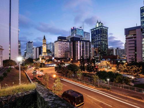 a city at night with a bus driving down a street at Mercure Brisbane King George Square in Brisbane
