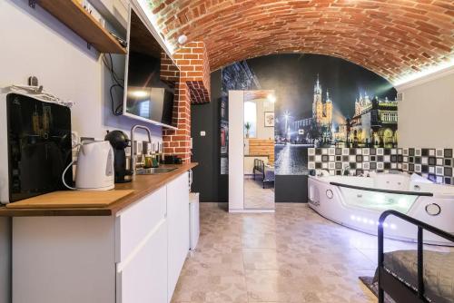 a kitchen with a brick wall and a bath tub at UNDERGROUND Jacuzzi Rooms in Krakow