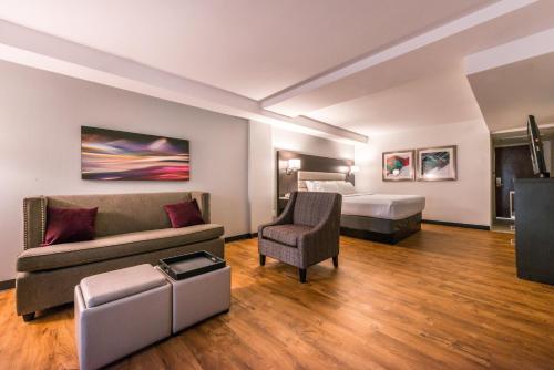 a hotel room with a bed and a couch at Holiday Inn Hotel and Suites Beaumont-Plaza I-10 & Walden by IHG in Beaumont