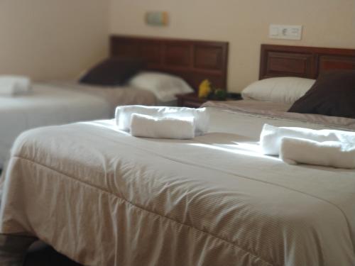 a hotel room with two beds and a white bedspread at Hostal Restaurante Iruñako in Burgos