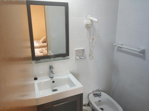 La salle de bains est pourvue d'un lavabo, d'un miroir et de toilettes. dans l'établissement Hostal Restaurante Iruñako, à Burgos