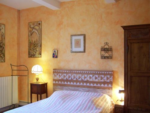 VaudreuilleにあるDomaine de Las Planquesのオレンジ色の壁のベッドルーム1室(ベッド1台付)