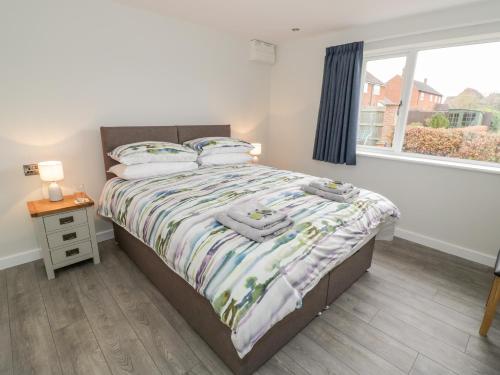 a bedroom with a bed and a window at Beechnut Cottage in Tewkesbury