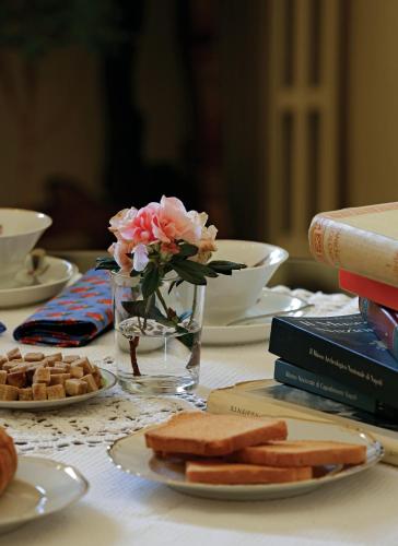 een tafel met een vaas met bloemen en enkele boeken bij B&B Luna Caprese in Napels