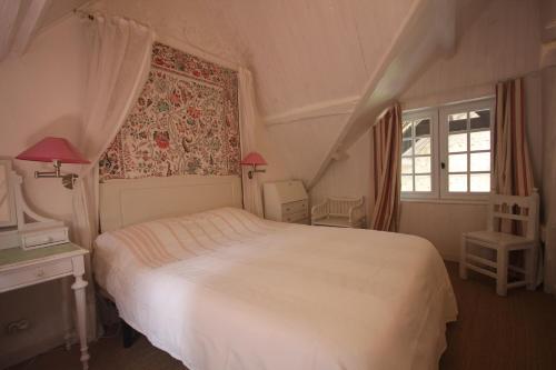 una camera con un letto bianco e una finestra di L'Etable du Domaine des Buissonnets a Écardenville-sur-Eure