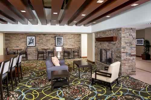 a lobby with a fireplace and chairs and tables at Staybridge Suites Atlanta - Midtown by IHG in Atlanta