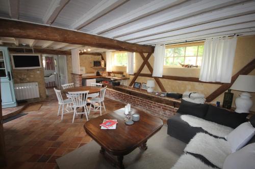 un salon avec un canapé et une table dans l'établissement L'Etable du Domaine des Buissonnets, à Écardenville-sur-Eure