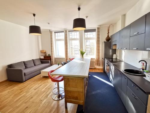 een keuken en woonkamer met een tafel en een bank bij Brivibas Center Apartments in Rīga