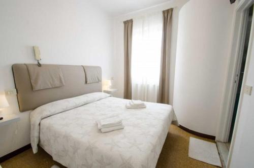 een slaapkamer met een wit bed en een raam bij Maison La Vela in Forte dei Marmi