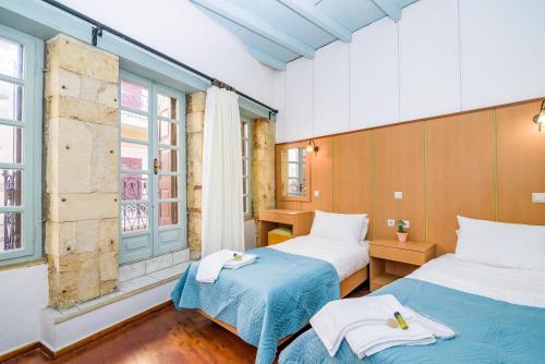 een kamer met 2 bedden en een raam bij Alegria Pension in Chania