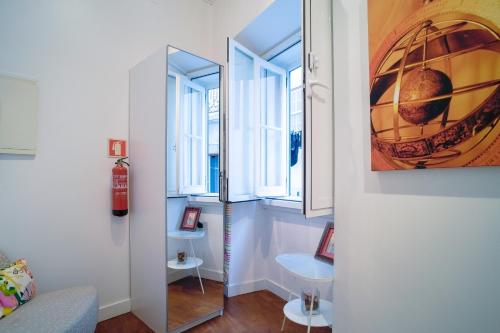 une chambre avec un miroir et 2 fenêtres dans l'établissement Lisbon Alfama S. Pedro Typical, à Lisbonne