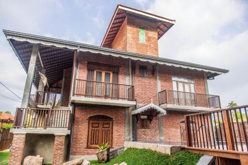 ネゴンボにあるNegombo Boutique Villaのバルコニー付きの大きなレンガ造りの家