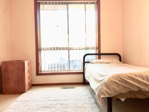 a bedroom with a bed and a window at Budget Clayton Homestay in Clayton North