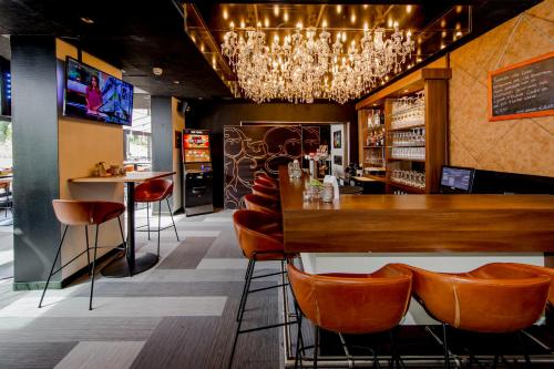 a restaurant with a bar with a table and chairs at Fletcher Hotel-Restaurant Jagershorst-Eindhoven in Leende