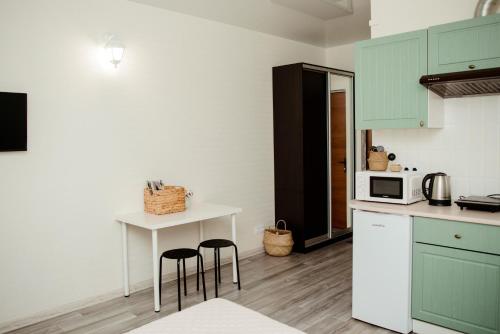 a kitchen with green cabinets and two stools in it at Apartments at Kontorska 10 in Kharkiv