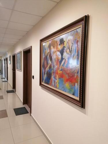 a painting hanging on a wall in a hallway at Hotel Lago Peshtera in Peshtera