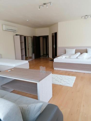 a living room with two beds and a table at Hotel Lago Peshtera in Peshtera