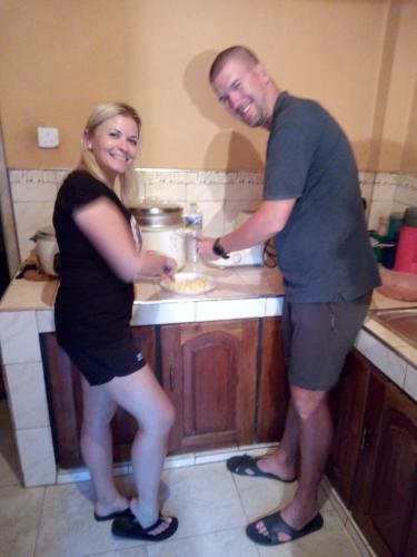 a man and a woman standing in a kitchen at Milan Home Stay in Ella