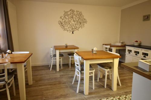 una cocina con mesas y sillas de madera en una habitación en Pension Willebuhr, en Mayen