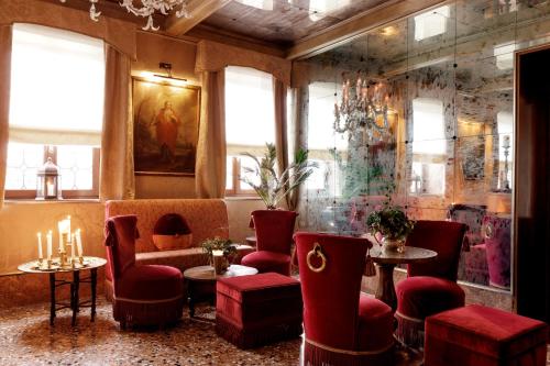 a restaurant with red chairs and a couch and tables at Hotel Metropole Venezia in Venice