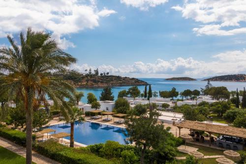 a view of a resort with a swimming pool and the ocean at Minos Beach Art Hotel, a Member of Design Hotels in Agios Nikolaos