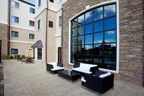 a patio with two benches and a large window at Staybridge Suites San Antonio Sea World by IHG in San Antonio