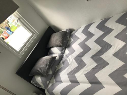 a bedroom with a bed with a checkered pillow at Grey Bunk House in Cheddar