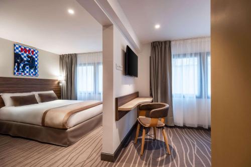 Quality Hotel Toulouse Centre في تولوز: غرفة في الفندق مع سرير ومكتب مع كرسي