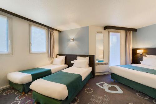 a hotel room with two beds and two windows at Kyriad Lille Gare - Grand Palais in Lille