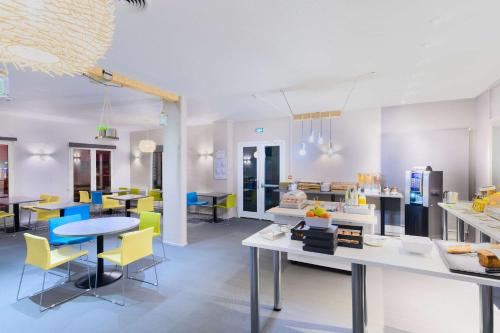 a room with tables and chairs and a cafeteria at Kyriad Lille Gare - Grand Palais in Lille