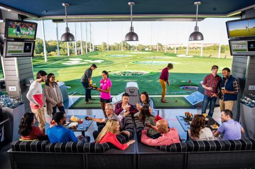 a group of people sitting in a room with a golf course mural at Staybridge Suites Midvale by IHG in Midvale