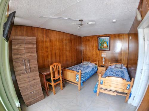 1 dormitorio con 1 cama y escritorio en una habitación en Hostal Sol y Luna, en Quito
