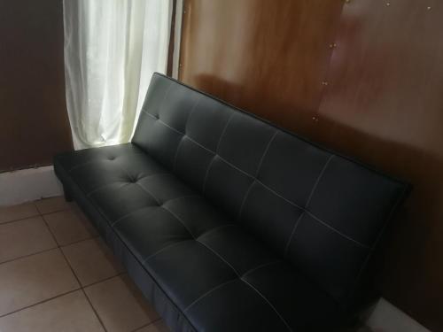 a black couch in a room with a window at Bijagua paradise Río Celeste in Bijagua