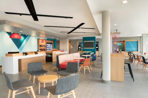 a lobby with chairs and tables and a cafeteria at avid hotel Oklahoma City - Quail Springs by IHG in Oklahoma City