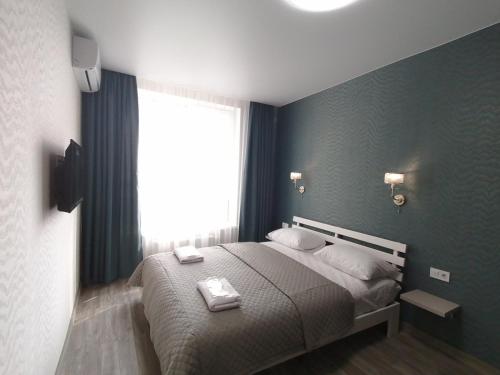a bedroom with a bed with two towels on it at Solo Apartment Kamenskaya in Kyiv