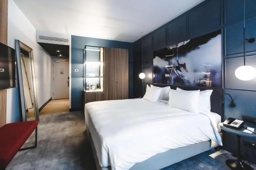 a bedroom with a large white bed and blue walls at Radisson Blu Hotel, Madrid Prado in Madrid