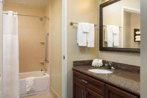 W łazience znajduje się umywalka, wanna i lustro. w obiekcie Staybridge Suites Toledo/Maumee, an IHG Hotel w mieście Maumee