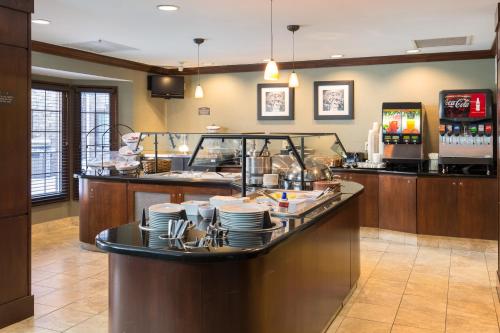 a restaurant with a counter with plates on it at Staybridge Suites Toledo/Maumee by IHG in Maumee