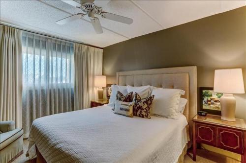 Un dormitorio con una cama y un ventilador de techo. en Oceans Of Amelia, en Fernandina Beach