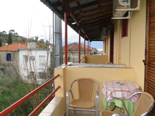 a patio with a table and chairs on a balcony at Porto Sabatiki in Sampatiki