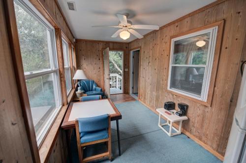 a room with a table and chairs and a ceiling fan at Outer Banks Motel - Village Accommodations in Buxton