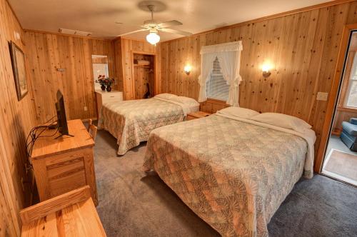a hotel room with two beds and a television at Outer Banks Motel - Village Accommodations in Buxton