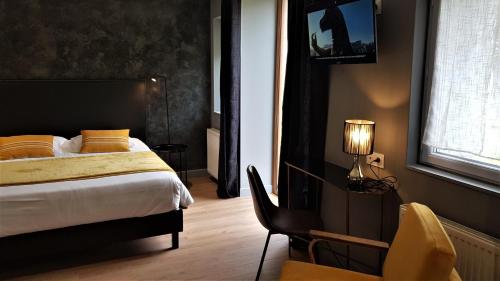 a bedroom with a bed and a chair and a window at Le Beaugency in Beaugency