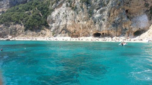 a group of people in the water at a beach at Appartamento Baus in Baunei