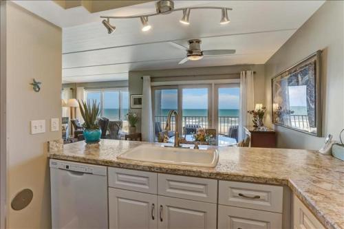 Una cocina con fregadero y vista al mar. en Oceans Of Amelia, en Fernandina Beach
