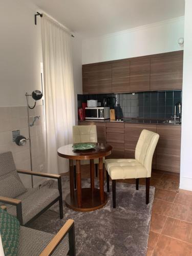 Il comprend un salon avec une table et des chaises ainsi qu'une cuisine. dans l'établissement Terrace Principe Real, à Lisbonne