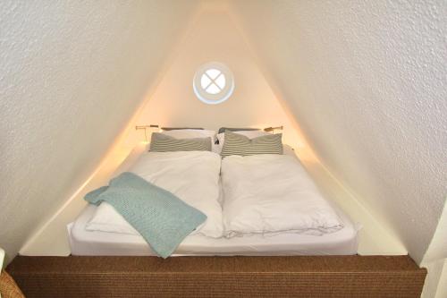 a bed with two pillows on it in a attic at Appartement Nordseesonne in Wenningstedt