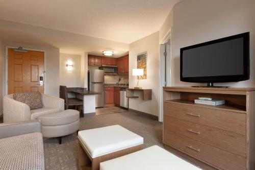 a living room with a flat screen tv on a cabinet at Staybridge Suites Tampa East- Brandon by IHG in Tampa