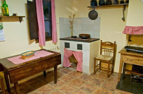 a kitchen with a stove and a table and a chair at Cal Gorro in Arnés