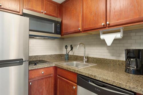 a kitchen with a sink and a refrigerator at Staybridge Suites Tampa East- Brandon by IHG in Tampa